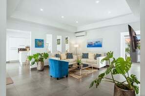 A spacious living area with a sofa set, a coffee table, and potted plants. - Lux 3-Bedroom Villa with Private Pool by Bocobay (Noord)