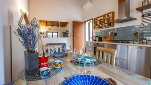 Uma sala de jantar com mesa de madeira, cadeiras e diversos copos e pratos.