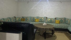 A room with a sofa, a round table, and a chair.