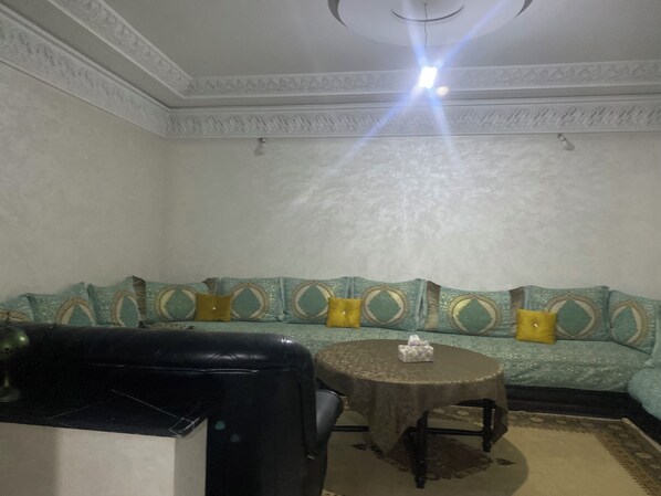 A room with a sofa, a round table, and a chair.