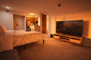 A bedroom with a large bed, a TV, and a kitchenette in the background. - Cozy 1-bedroom apartment in brilliant Marina del Rey with AC Close TO Venice (Marina del Rey)