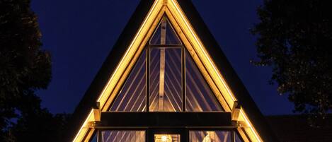 A triangular building with large windows and a central light fixture.