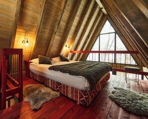 A high-ceilinged wooden room with a bed, a fur rug, and a window. - Hai la Munte Bran (Bran)
