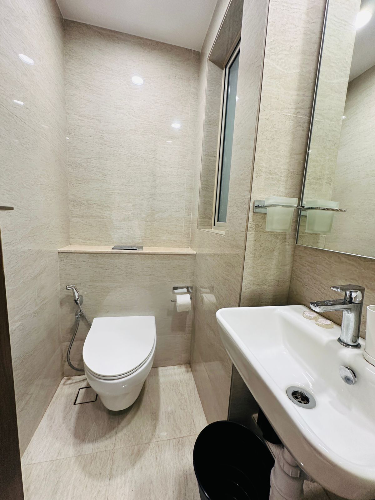 A modern bathroom with a toilet, sink, and a glass shower enclosure.