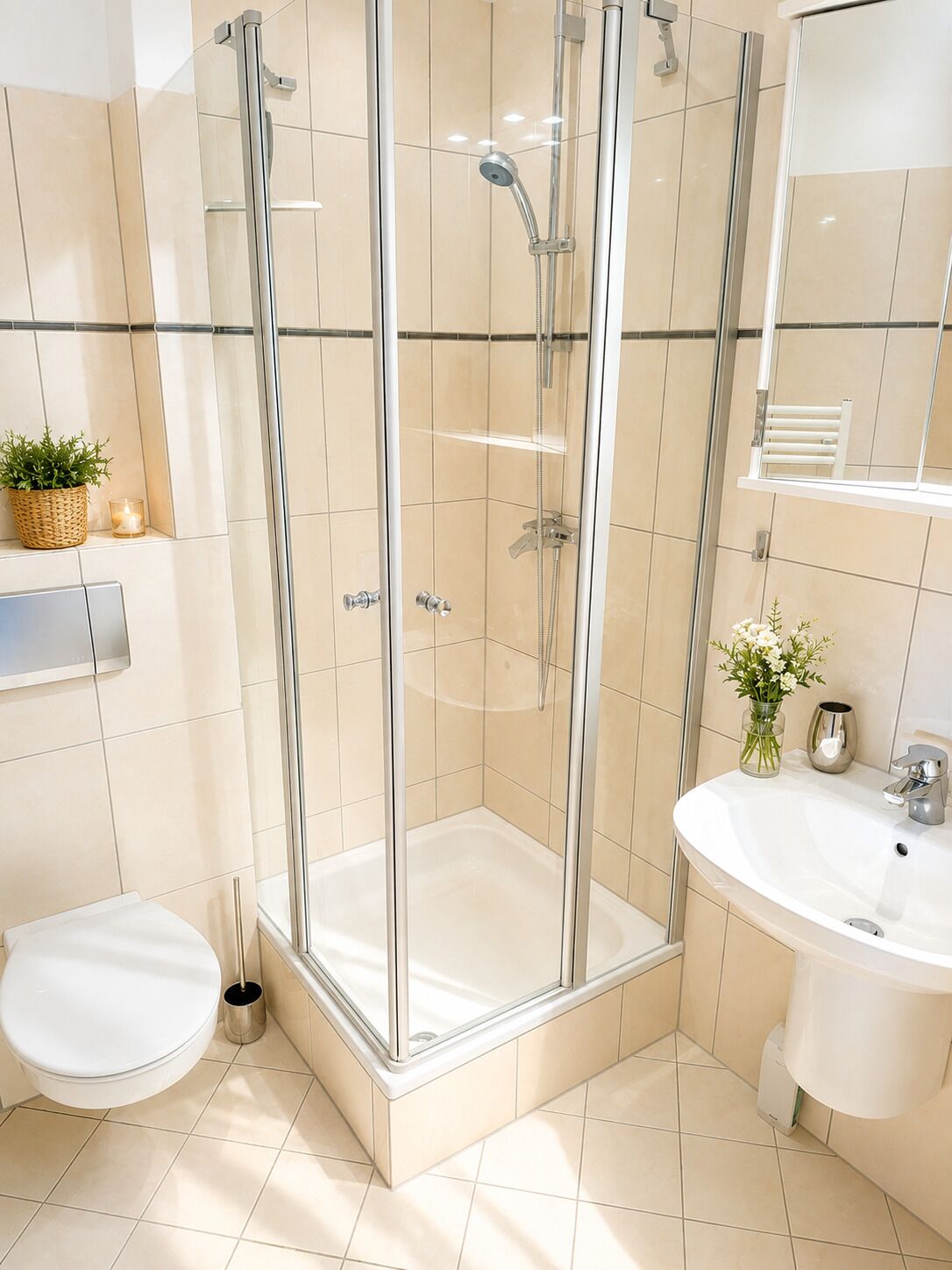A modern bathroom with a glass-enclosed shower, a white sink, and a toilet.