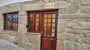 Un edificio de piedra con puerta y ventanas de madera, que dice 'Casa do Mel'.