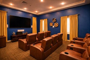 Ein Heimkino mit blauen Wänden, gelben Vorhängen und Ledersessel-Sitzen.