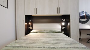 A bedroom with a bed, bedside lamps, a nightstand, and a mirror on the wall. - Suite dei Vanni - Free private parking (Florence)