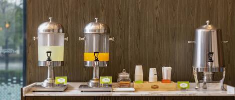 A coffee station with three coffee machines, a scale, and a stack of disposable cups.