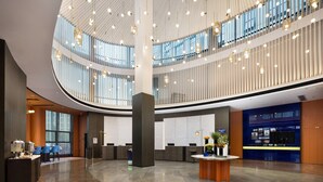 A spacious lobby with a high ceiling, multiple seating areas, and a reception desk. - Hampton by Hilton (Pingxiang)