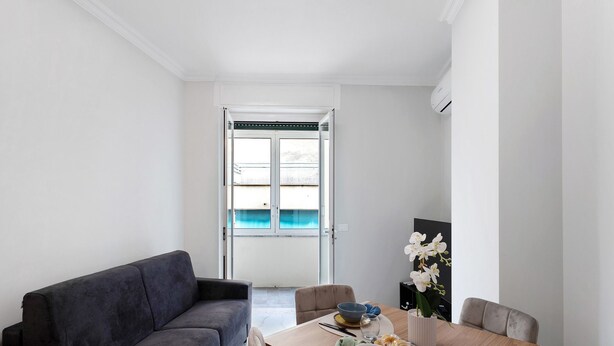 A modern living room with a sofa, dining table, and chairs. - Apartment 'Casa Giuseppe Centro - Sanremo' with Sea View near Piazza Colombo (Sanremo)
