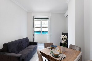 Ein modernes Wohnzimmer mit einer Couch, einem Esstisch und Stühlen.