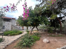 A stone building with a stone pathway leading to a seating area.