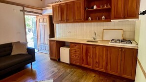 A kitchen with wooden cabinets, a countertop, and a stove. - Zeytin Evi (Datca)