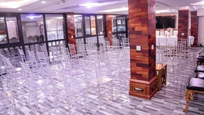 A spacious hall with rows of clear plastic chairs and a wooden pillar. - lynna hôtel (Yaoundé)