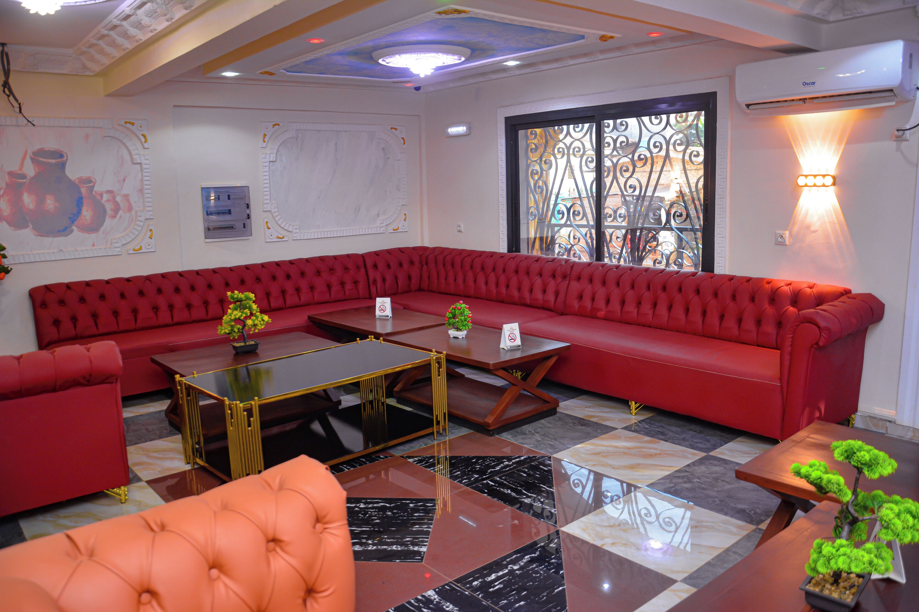 A modern hotel lobby with a red sofa, a glass coffee table, and a decorative plant.
