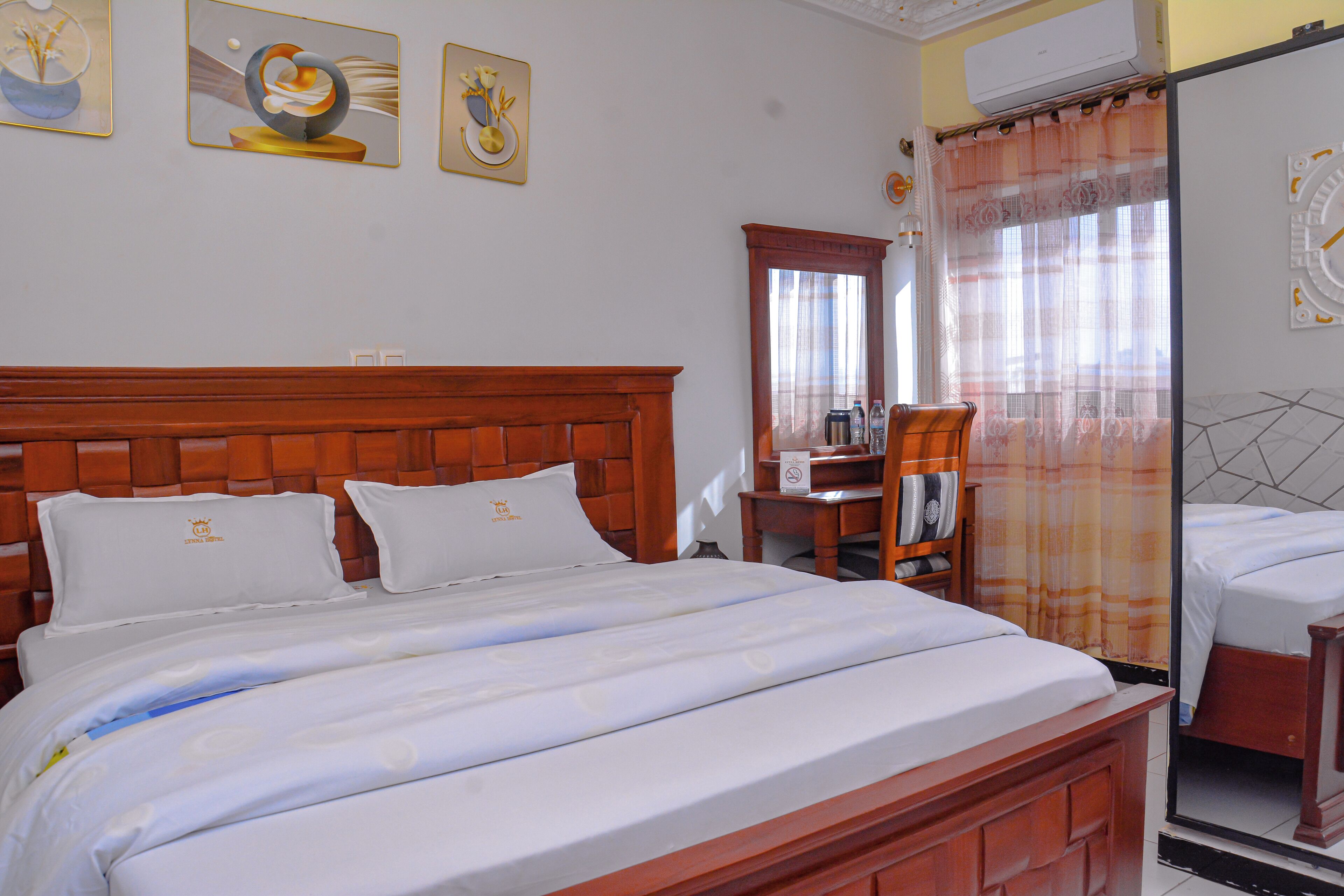 Een hotelkamer met een houten bed, een bureau en een stoel.