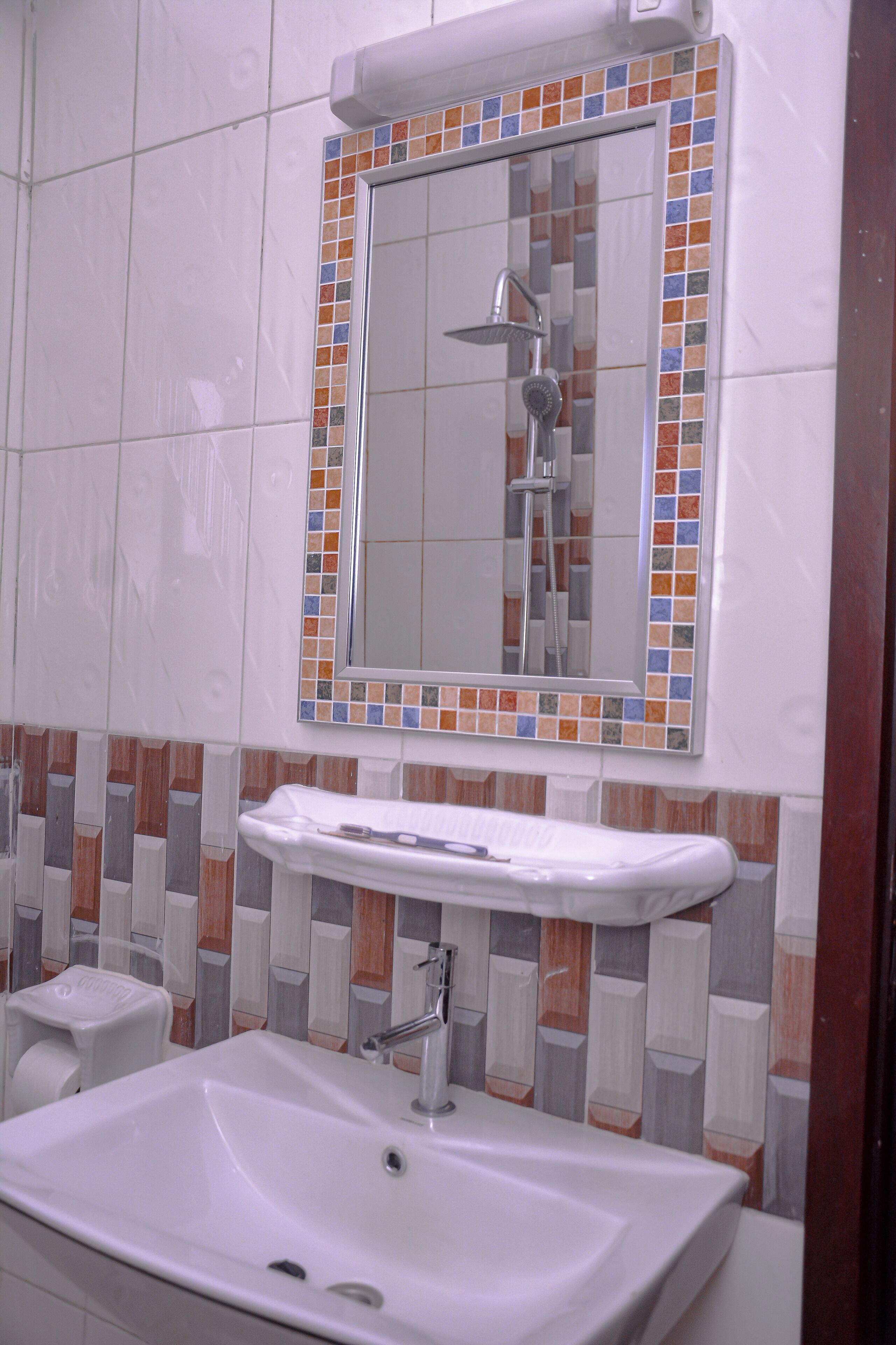 A bathroom with a white sink, a mirror, and a shower.