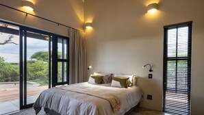 Een moderne slaapkamer met een groot bed, uitzicht op de omgeving en een schuifdeur van glas.