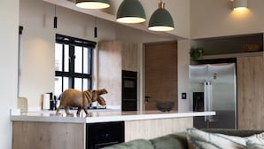 Een moderne keuken met een houten kookeiland, hanglampen en een groot raam.