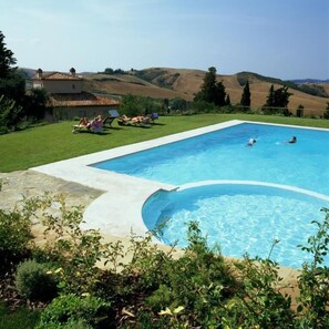 Una piscina al aire libre de temporada, tumbonas
