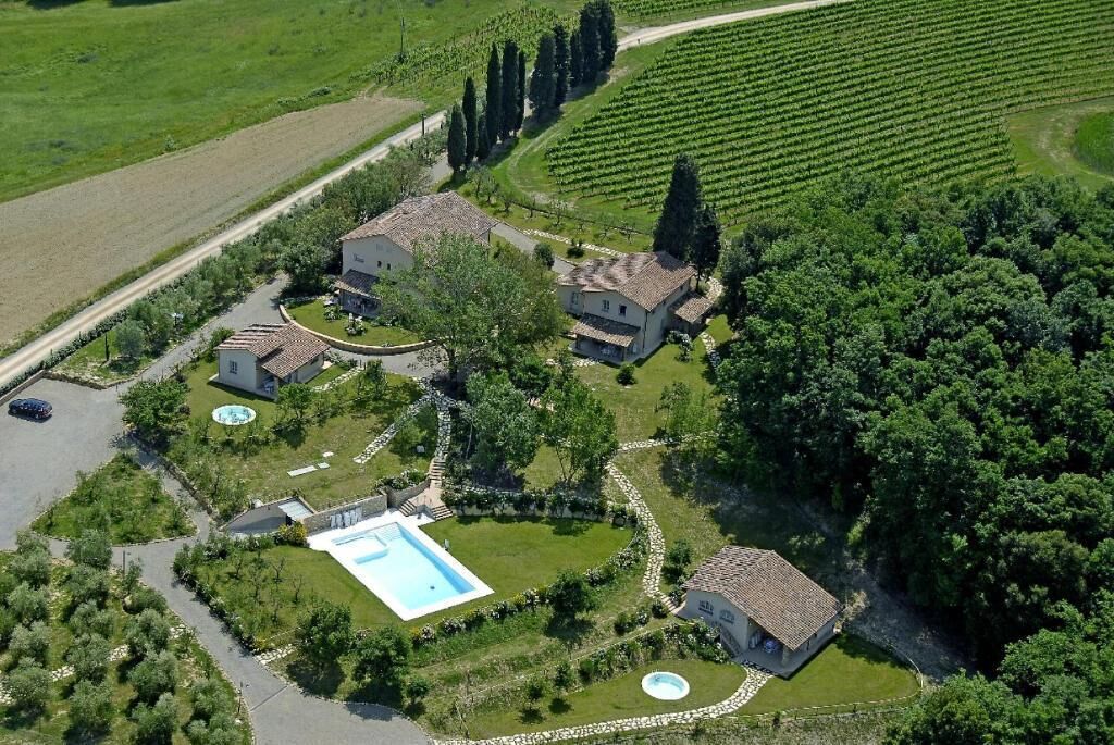 A large estate with multiple buildings, a swimming pool, and vineyard fields.