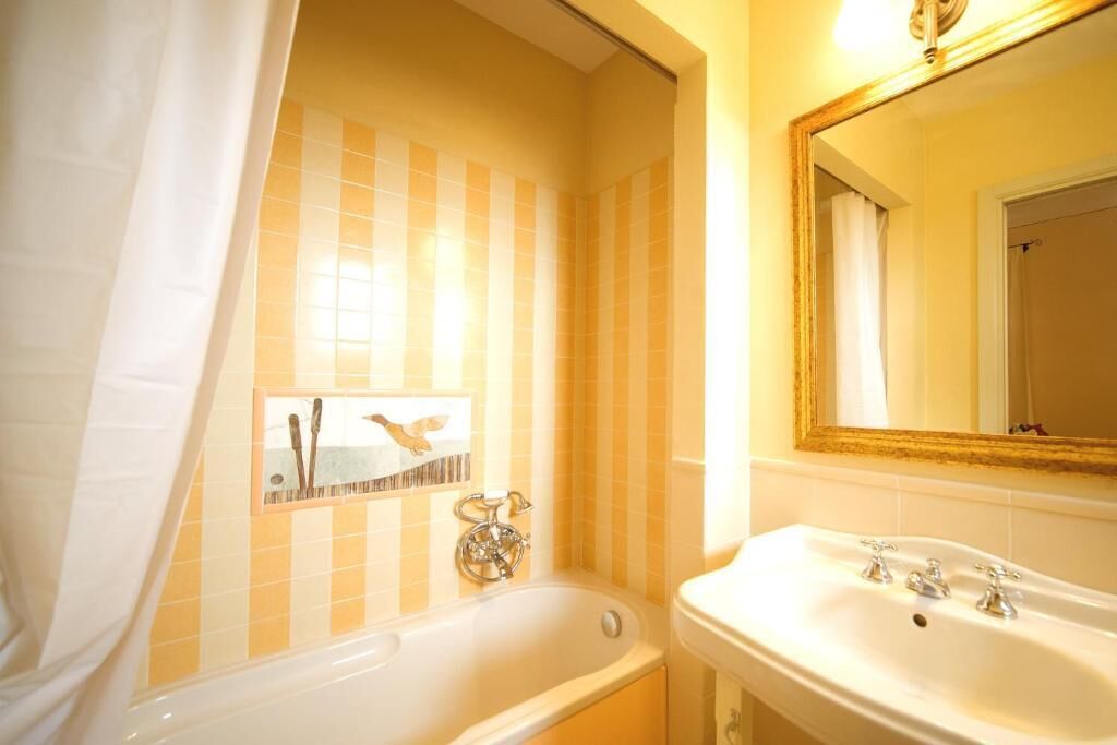 Ein Badezimmer mit einer Badewanne, einem Waschbecken und einem Spiegel.