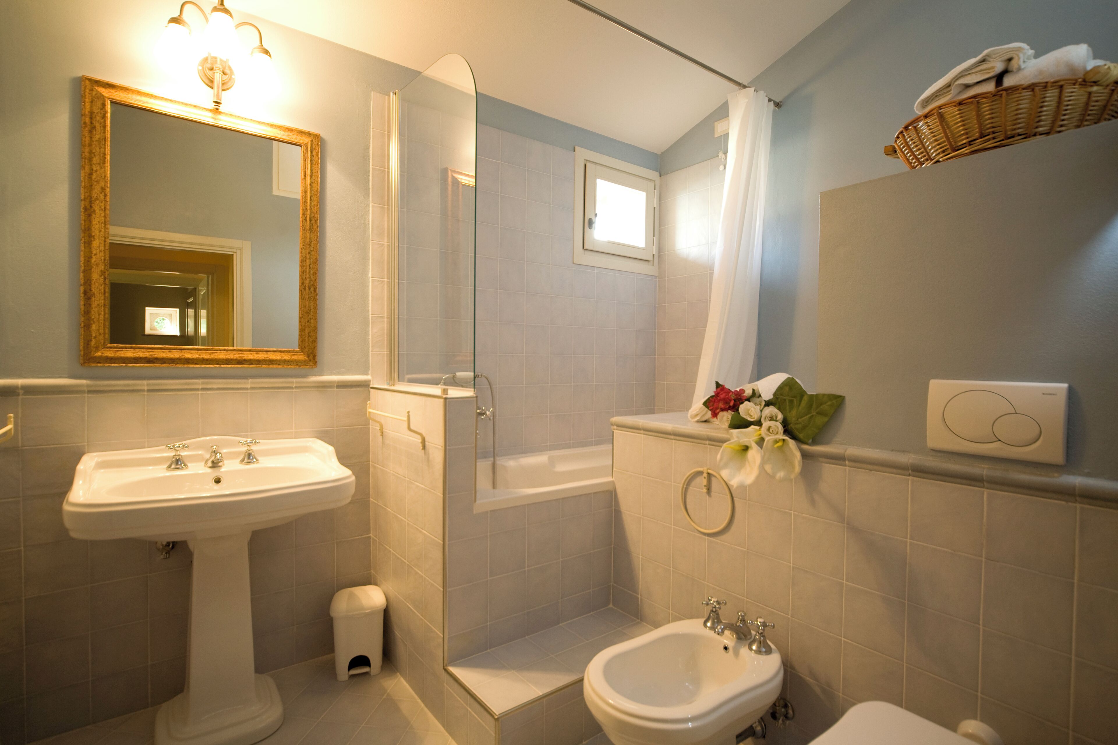 Une salle de bain équipée d’un lavabo sur colonne, d’une baignoire, de toilettes et d’un bidet.