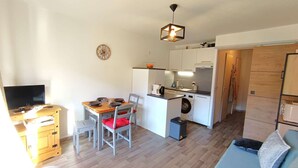 A compact living space with a dining area, kitchenette, and a sofa. - Studio Cabin for 4 in Vielle Aure with Parking (Vielle-Aure)