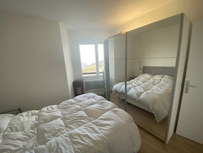 A bedroom with a bed, a wardrobe, and a window.