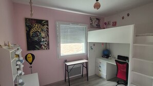 Une pièce comprenant un bureau, une chaise et un lit.