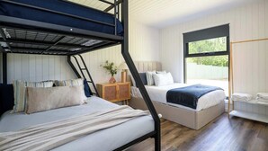 A bunk bed room with a window, a bedside table, and a lamp. - Wood Duck Daylesford (Daylesford)