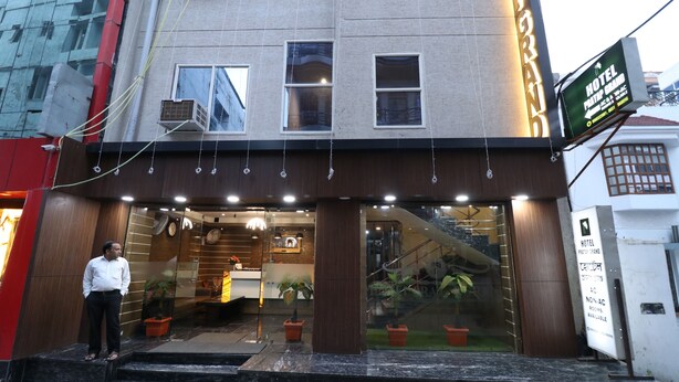 L'entrée d'un hôtel au design moderne, avec un comptoir d'accueil, des plantes en pot et un escalier menant au hall d'entrée.