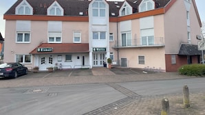 A multi-story hotel with a flat roof and large windows. - Hotel Esmer (Lollar)