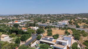 Un quartier résidentiel avec des maisons modernes, une autoroute et un ciel dégagé.