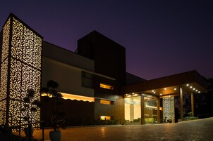 Un edificio moderno con una entrada bien iluminada y un muro decorativo.