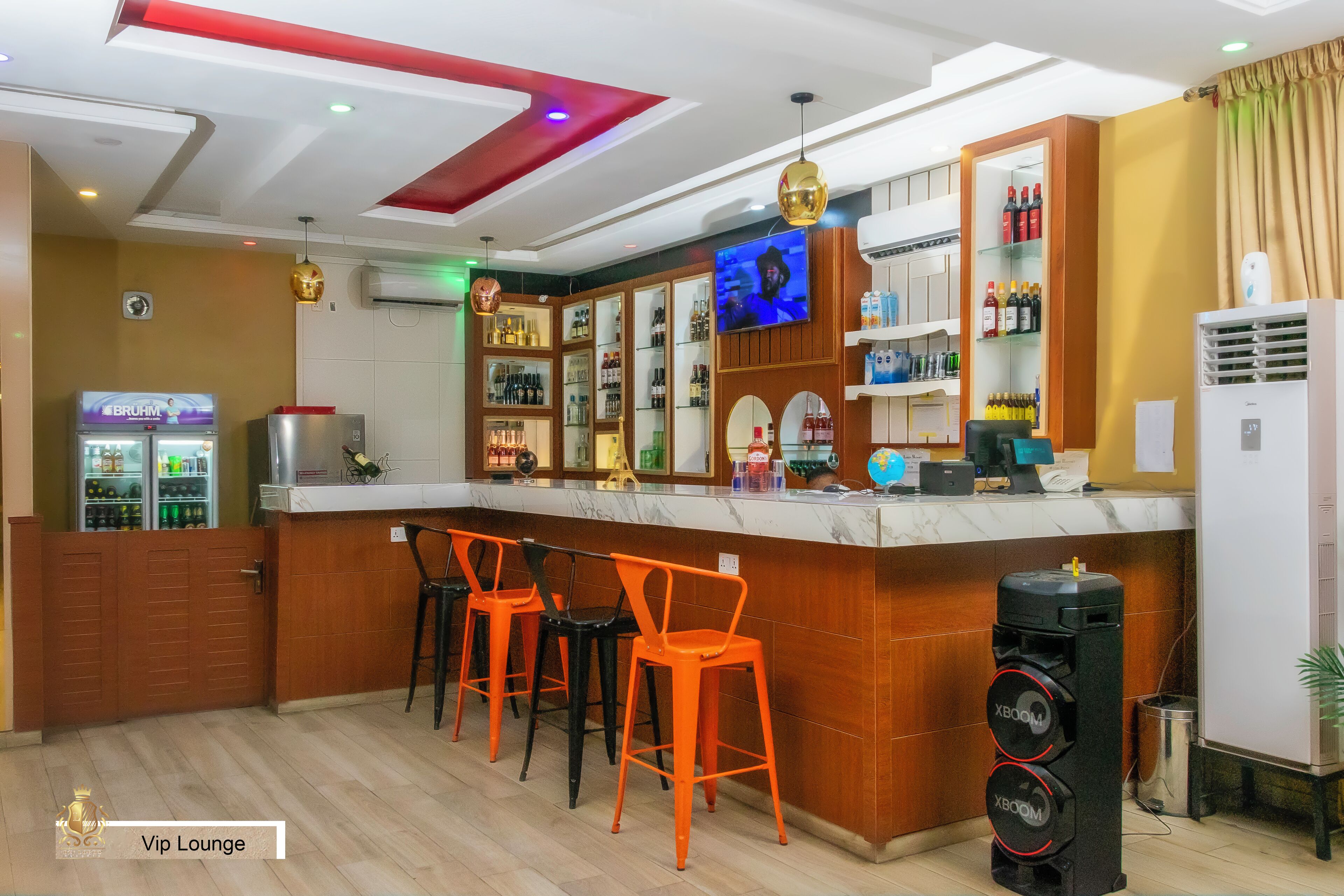 A bar area with a counter, bar stools, and a television screen.