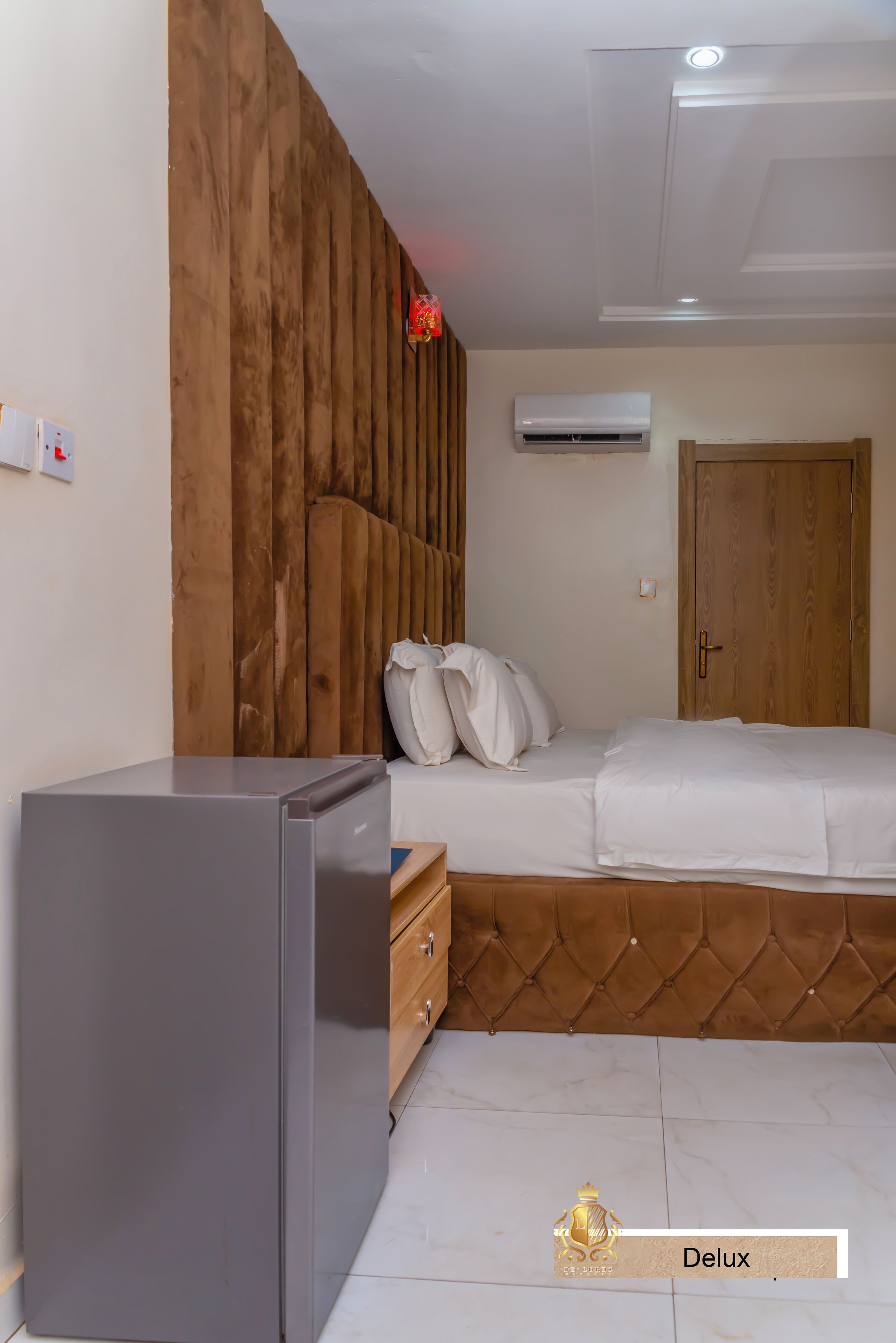 Un dormitorio con cama, cabecera de madera, armario y un pequeño escritorio.