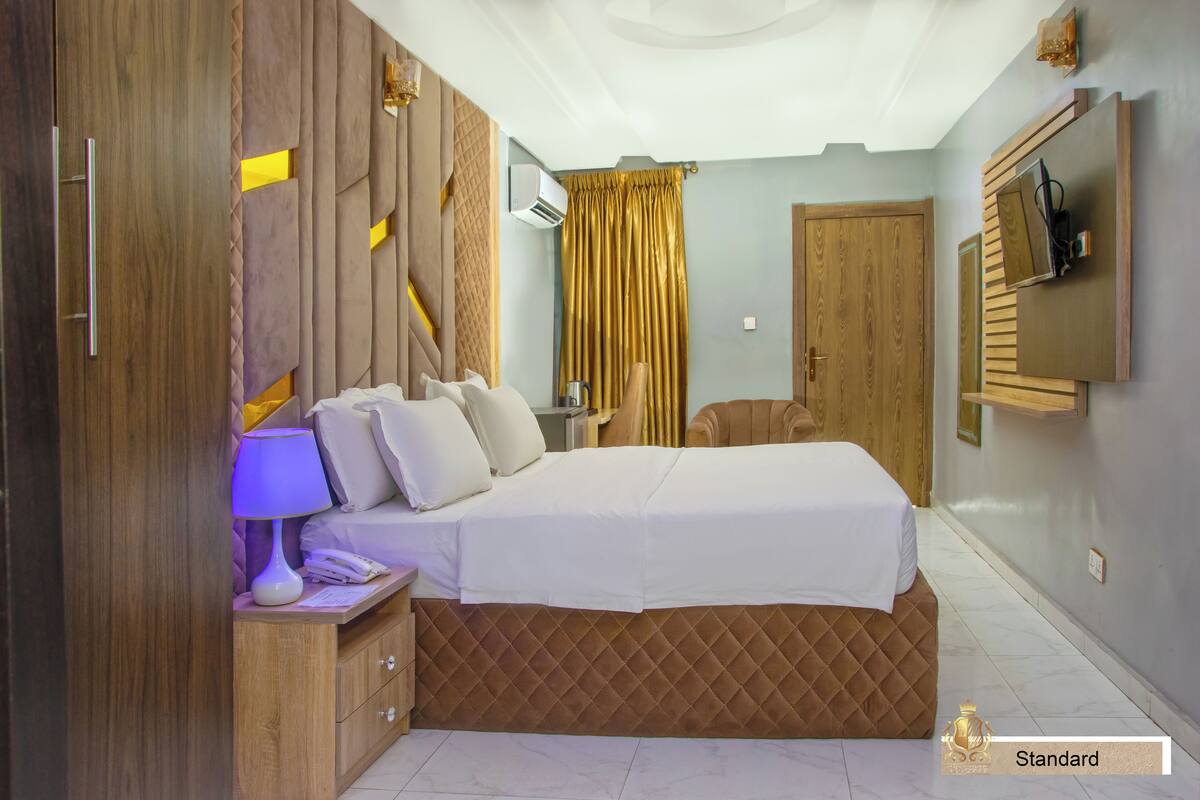 Une chambre à coucher avec un lit, une table de chevet, une lampe et une armoire.
