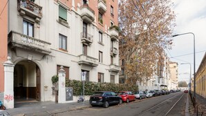 A row of parked cars along a street with a tram track, a building with balconies, and a tree with autumn leaves. - A comfortable 70 square meters apartment, perfect for five people, located on the fifth floor of a building with an elevator (NOT accessible to disabled guests).The property is located near Via Cenisio, a short distance from the Monumental Cemetery: its  (Milan)