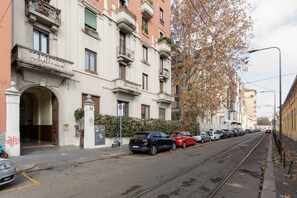 A row of parked cars along a street with a tram track, a building with balconies, and a tree with autumn leaves. - A comfortable 70 square meters apartment, perfect for five people, located on the fifth floor of a building with an elevator (NOT accessible to disabled guests).The property is located near Via Cenisio, a short distance from the Monumental Cemetery: its  (Milan)