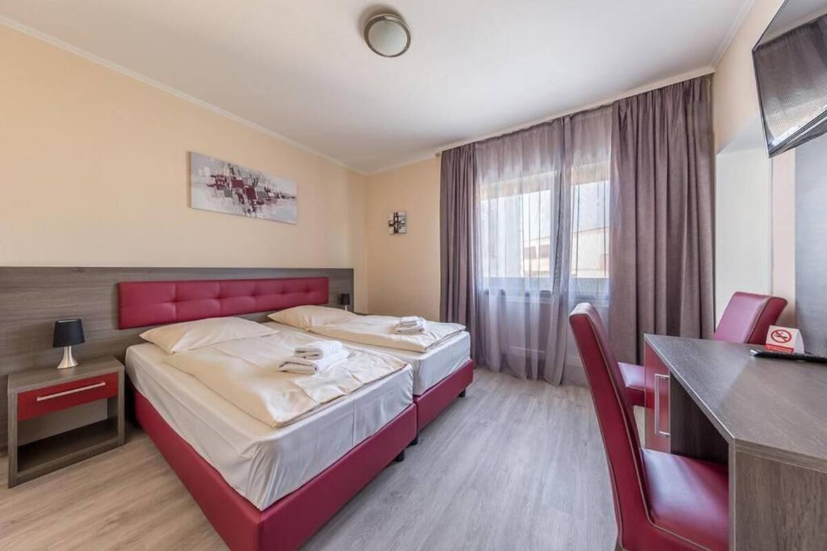 Een hotelkamer met twee bedden, een bureau en een stoel.