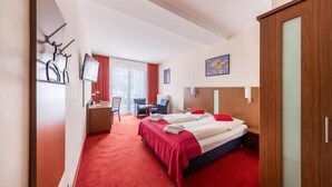 A hotel room with a bed, desk, chair, and a television. - Hotel Klein (Frankfurt)