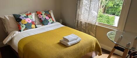 Tabla de planchar con plancha, internet y ropa de cama