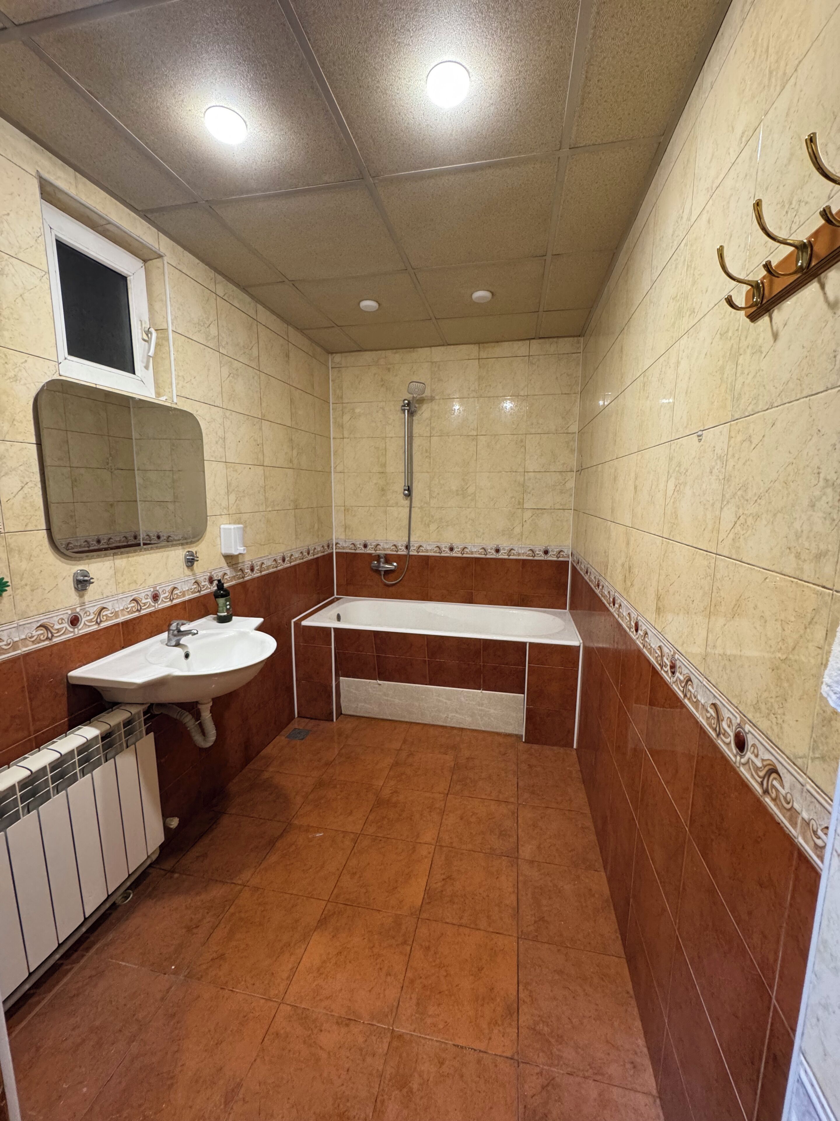 A bathroom with a sink, mirror, shower, and bathtub.