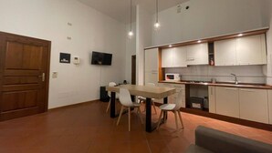 Une cuisine moderne avec des armoires blanches, un plan de travail en bois et un four à micro-ondes encastré.