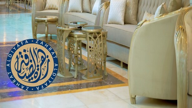 Un vestíbulo espacioso con un sofá grande, varios sillones y mesas decorativas.