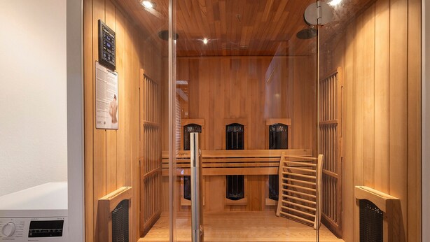 A sauna with wooden walls, a bench, and a ventilation system. - Luxury Holiday Home with Sauna, Fireplace, Pool Table, Garden, BBQ & Plenty of Space to Relax (Klein Rönnau)