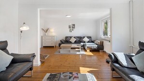 A modern living room with a sofa, coffee table, and a lamp. - Luxury Holiday Home with Sauna, Fireplace, Pool Table, Garden, BBQ & Plenty of Space to Relax (Klein Rönnau)