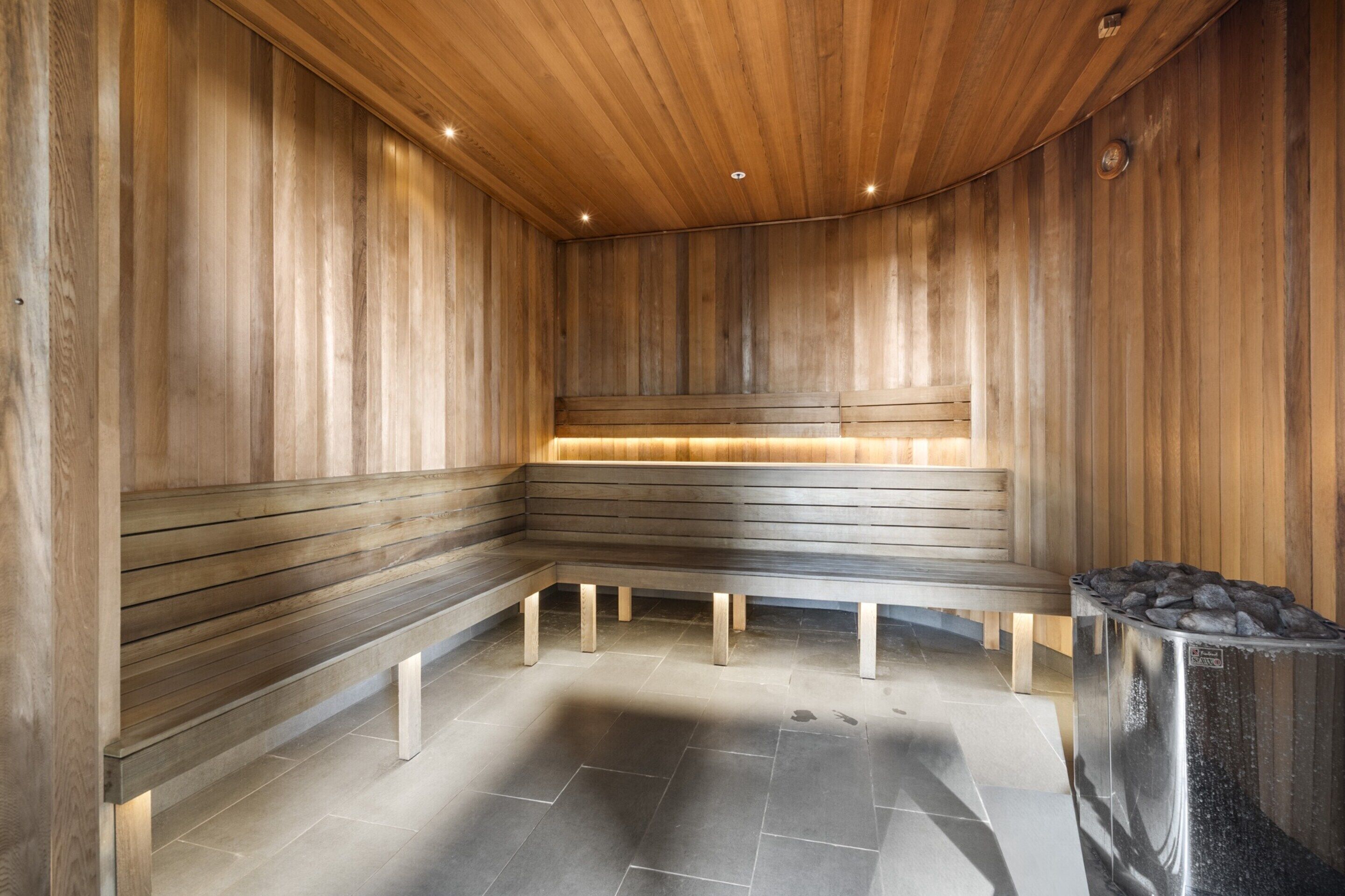 A sauna with wooden benches and a stone floor.